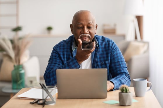 Senior Using Voice Search On Smartphone In Office
