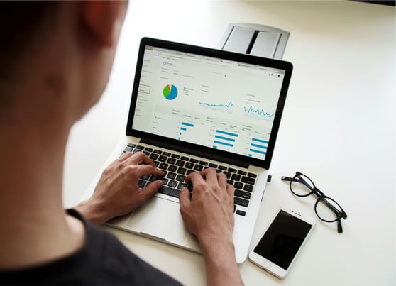 Looking over man's shoulder to his laptop screen with Google Analytics
